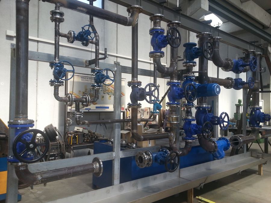 Collettore di tubazioni con valvole blu in fase di prefabbricazione in officina
