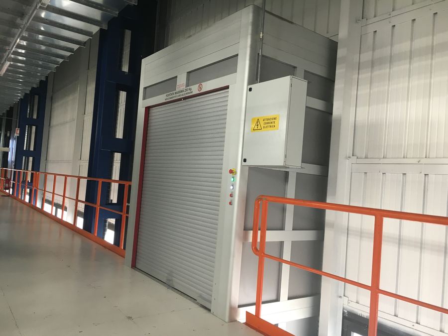Portone rapido a impacchettamento installato lungo un corridoio di stabilimento